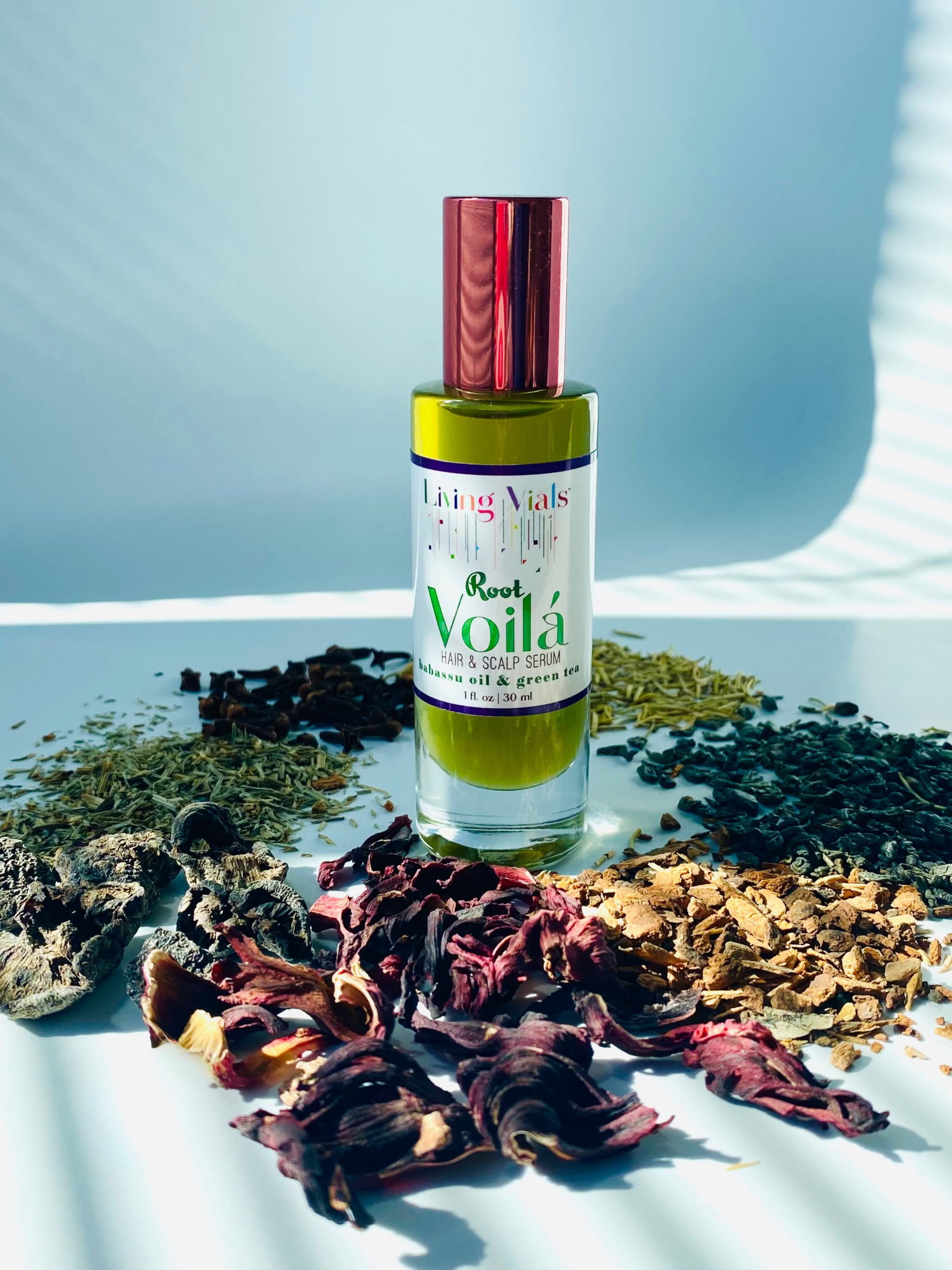 Bottle of Voila oil with dried herbs on a white surface